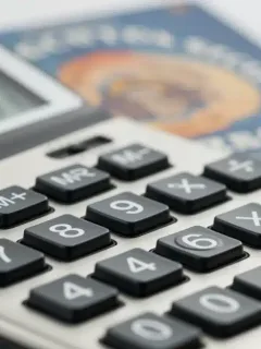 Calculator displaying financial data with Social Security card, representing 2026 COLA increase.